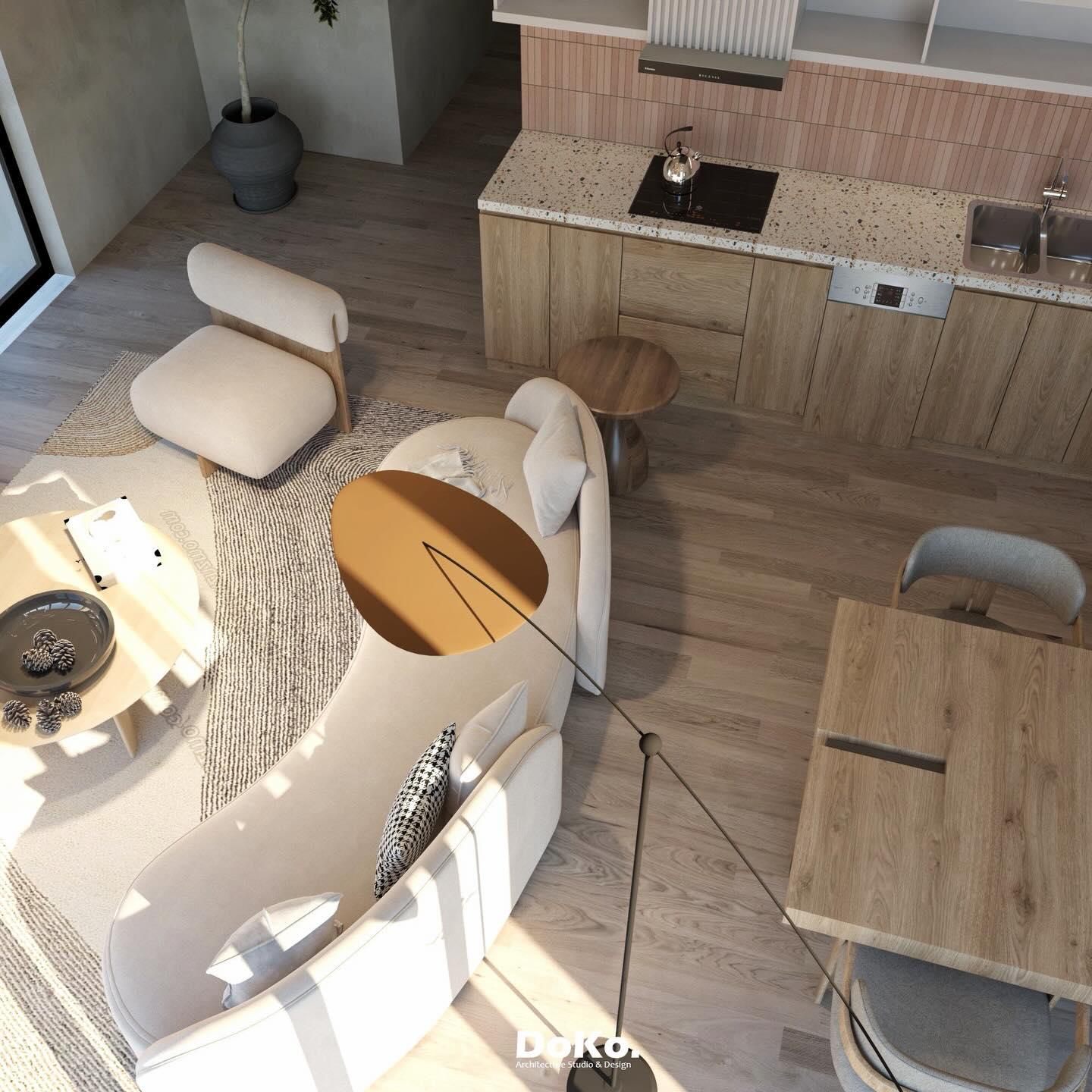 Top-down view of the curved sofa, side tables, floor lamp and the kitchen island beyond.