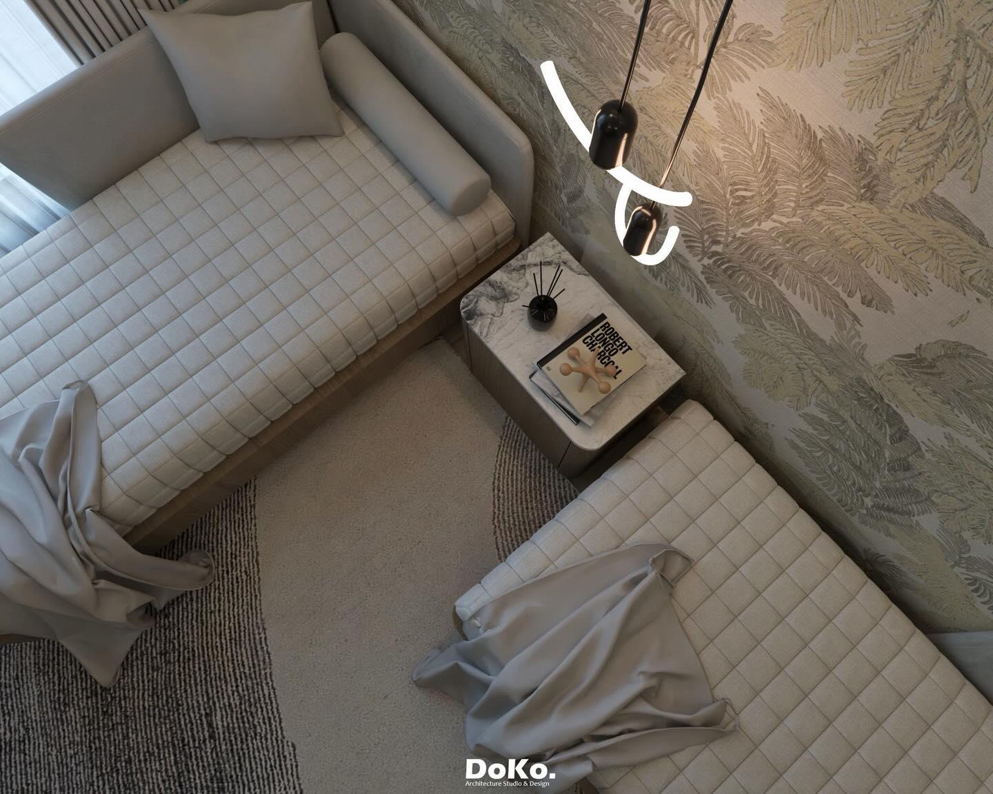 Top-down view of the beach bedroom: quilted beds, a bedside table and a sculptural pendant beside the botanical mural wall.