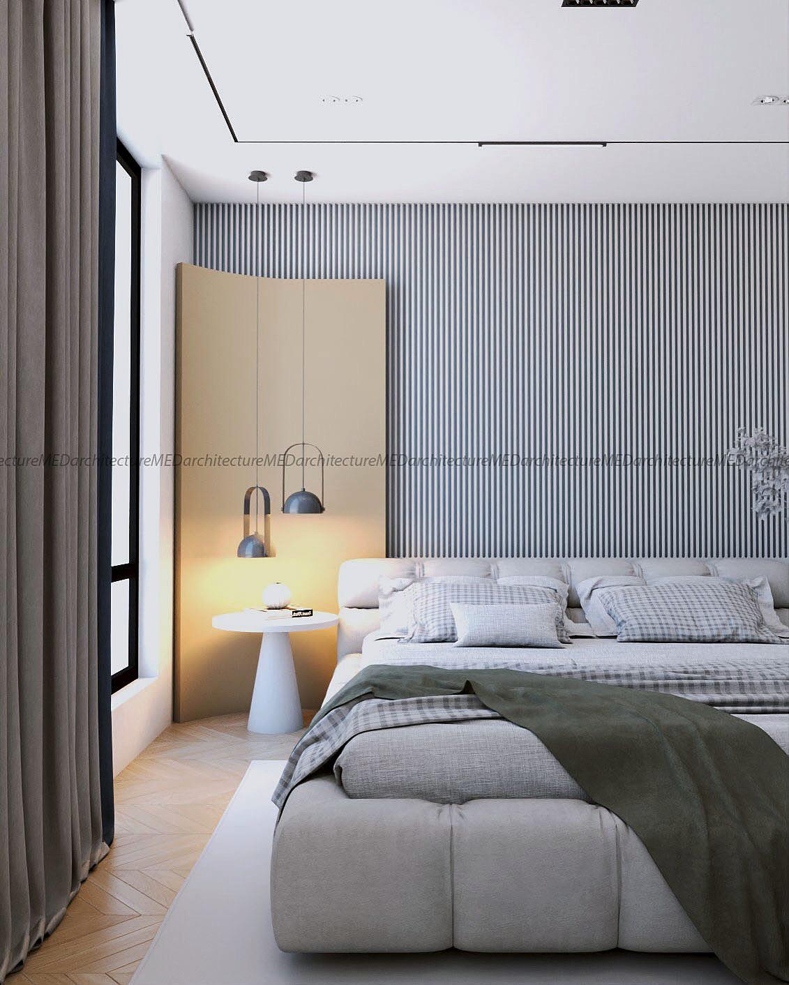 The bedroom with its fluted grey wall, upholstered bed, round side table and reading lamp.