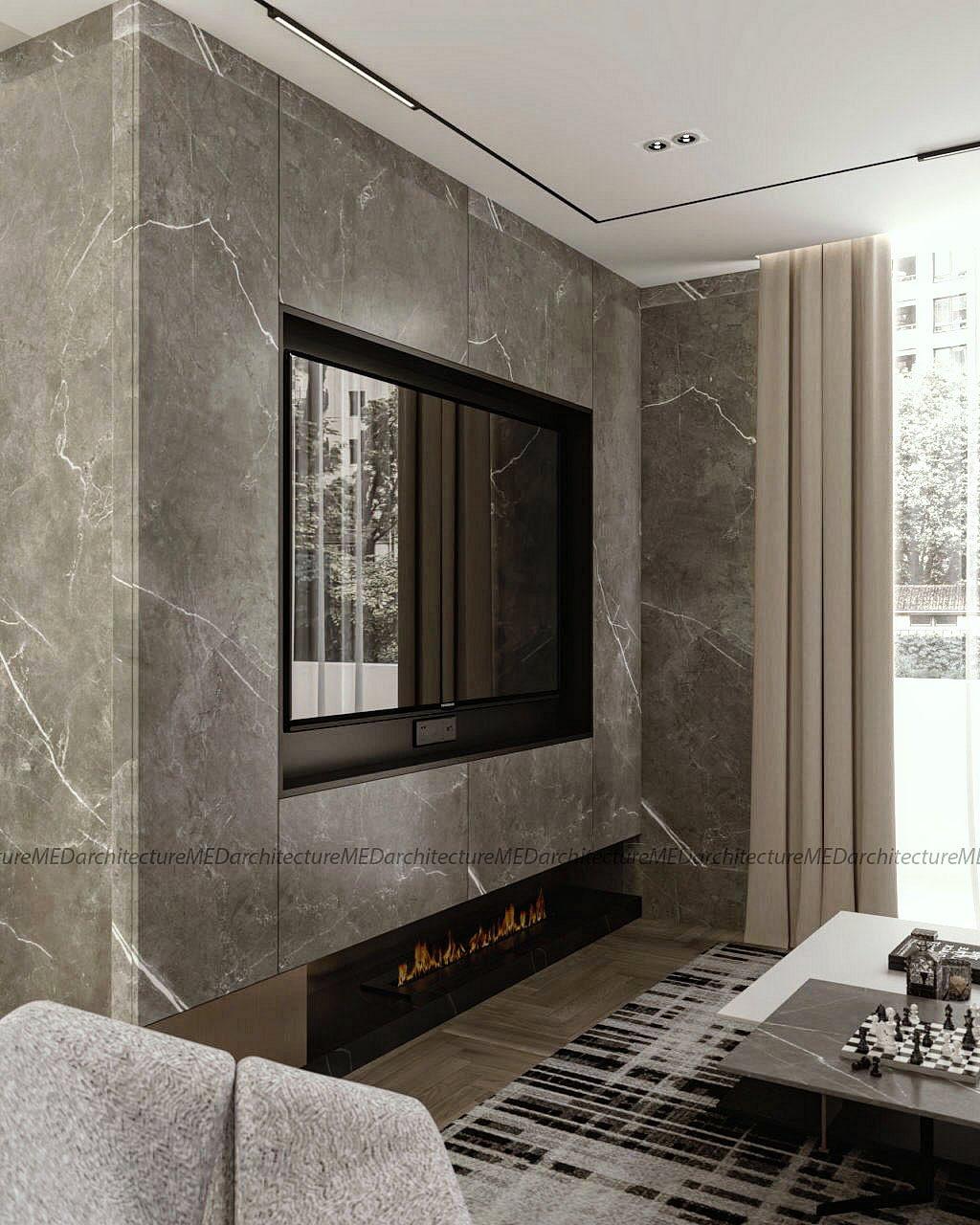 Living room with a large grey marble wall, integrated TV and linear fireplace, a patterned rug and a chess table.
