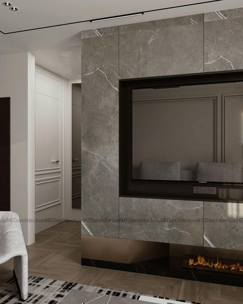The marble TV wall and fireplace seen from the side, next to a white panelled door.